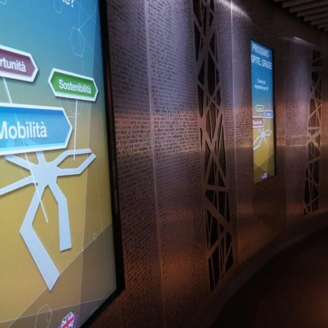 Vertical interactive screens along a curved exhibition wall at the Dubai pavilion in Expo Milan.