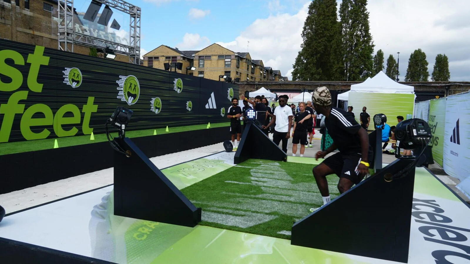 Participant moving through an interactive football challenge on a green Adidas Crazyfast course.