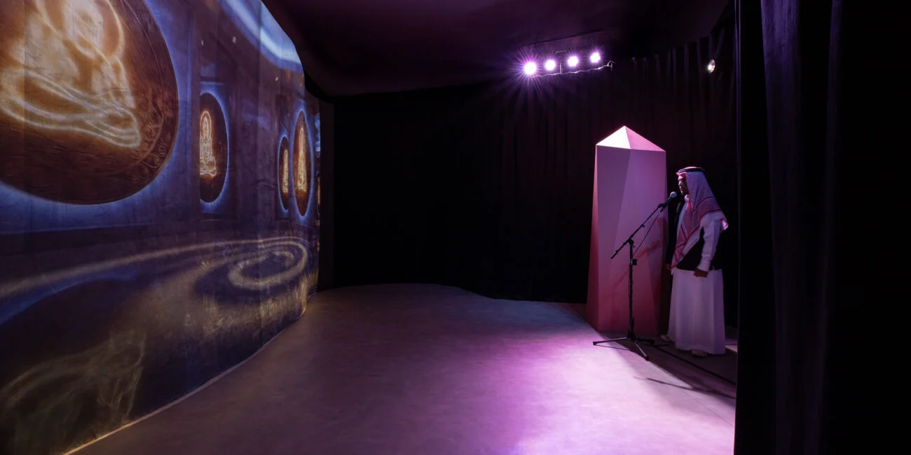 Curved projection wall and microphone station in the purple-lit Ascended Intelligence installation.