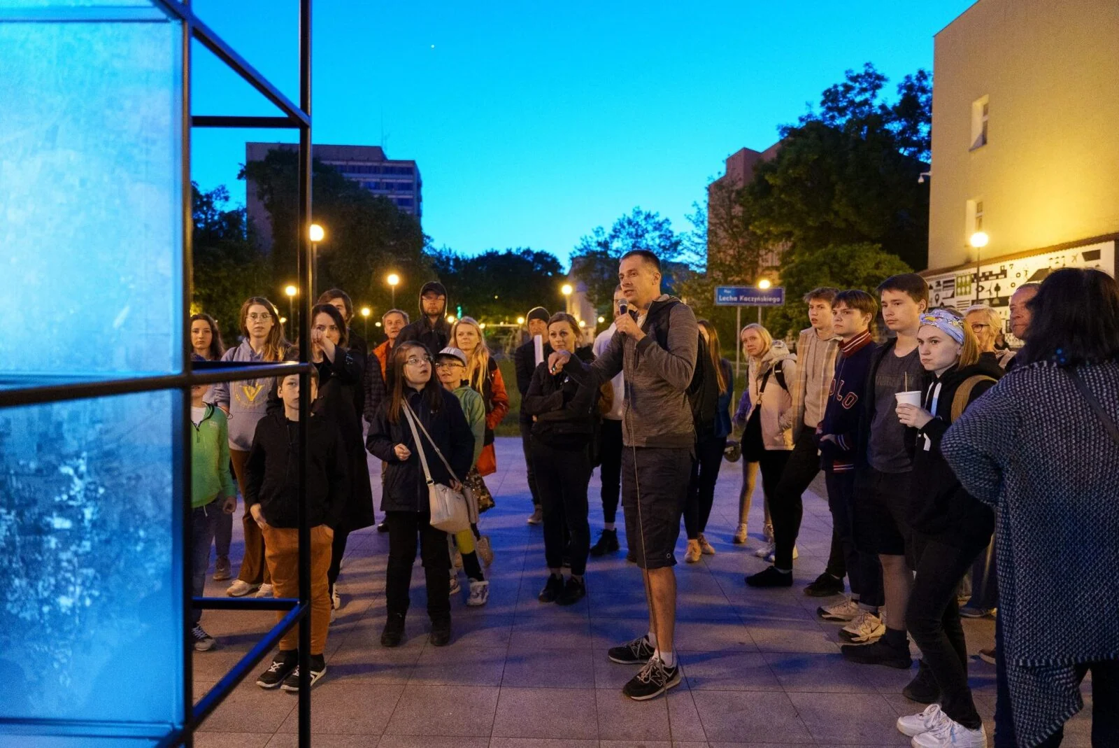Group gathered beside an illuminated Direction Earth/Space display during an evening presentation.