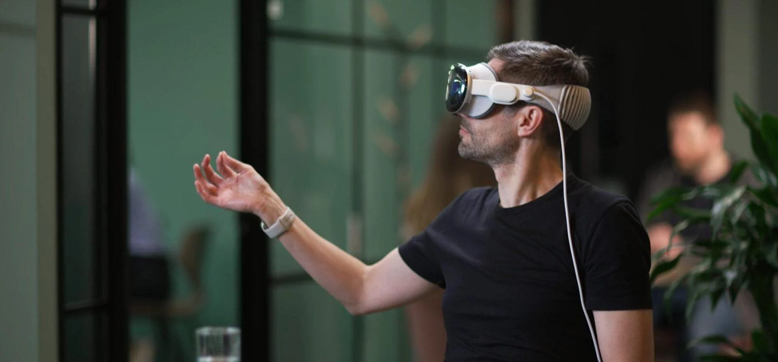 Person wearing a spatial-computing headset and raising a hand during the Discover London experience.