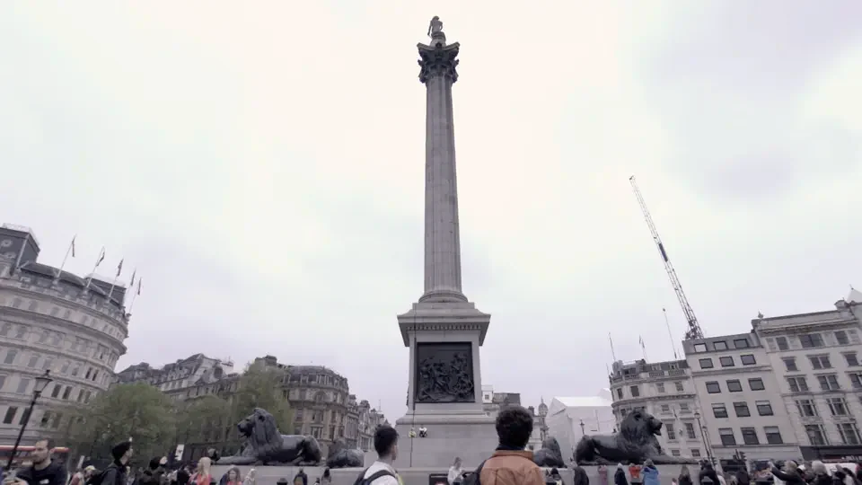 Nelson's Column rising above visitors in Trafalgar Square, London.