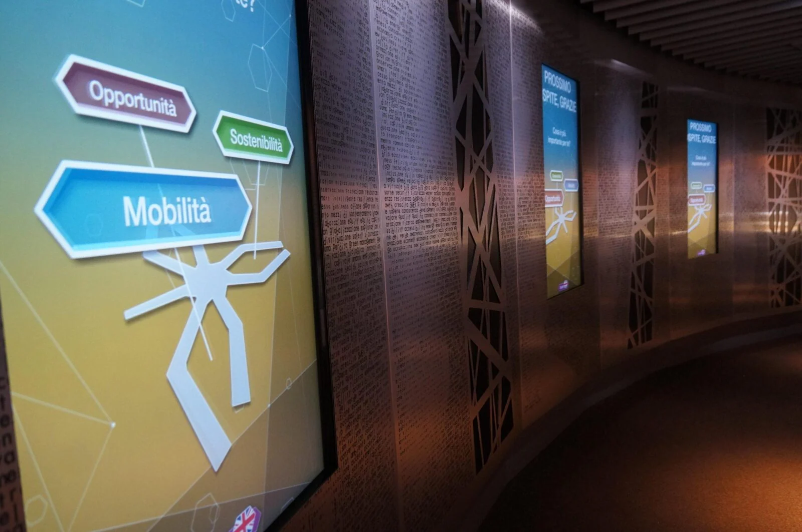 Vertical interactive screens along a curved exhibition wall at the Dubai pavilion in Expo Milan.
