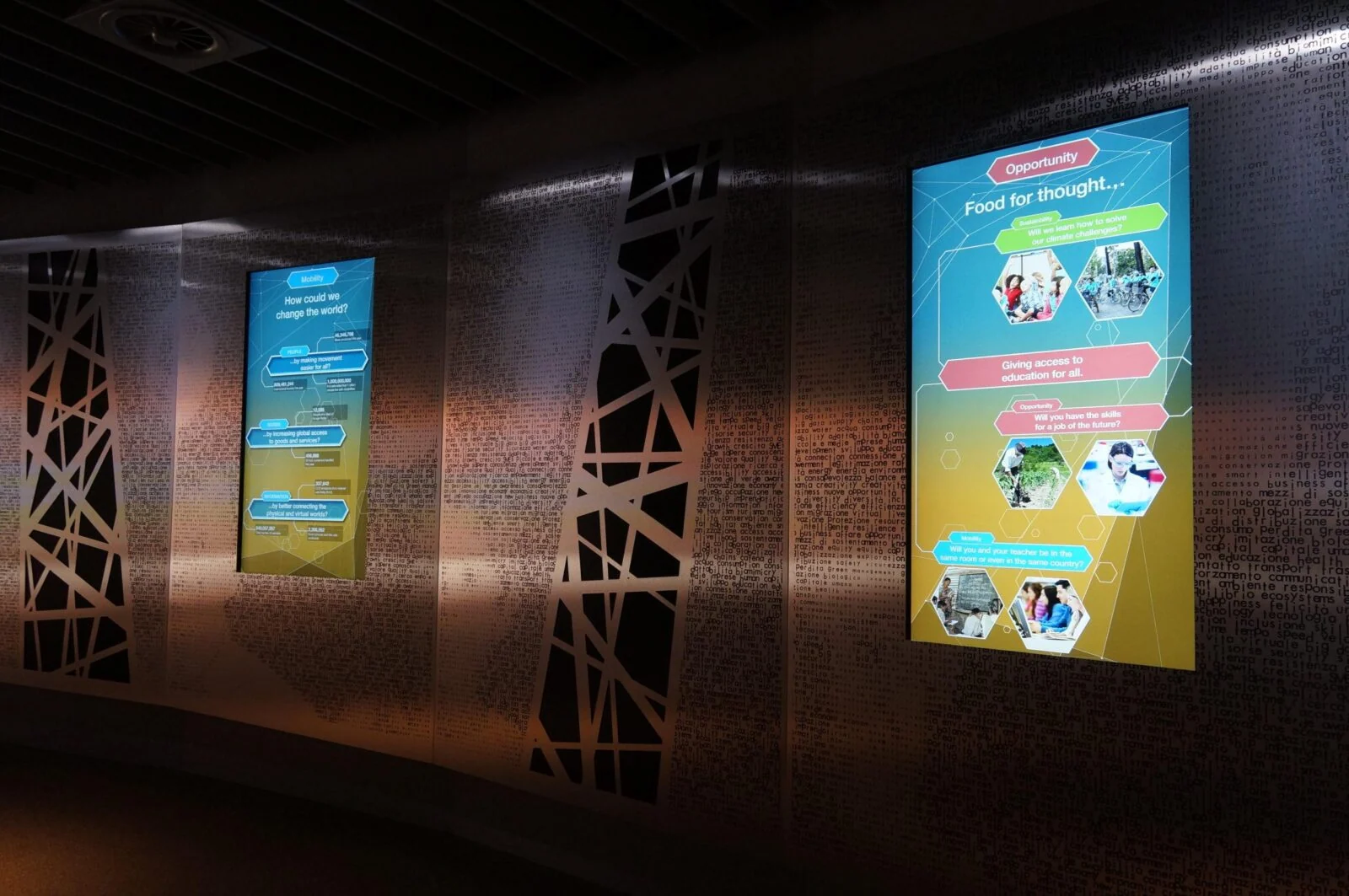Two colourful information screens set into patterned exhibition walls at the Dubai pavilion.