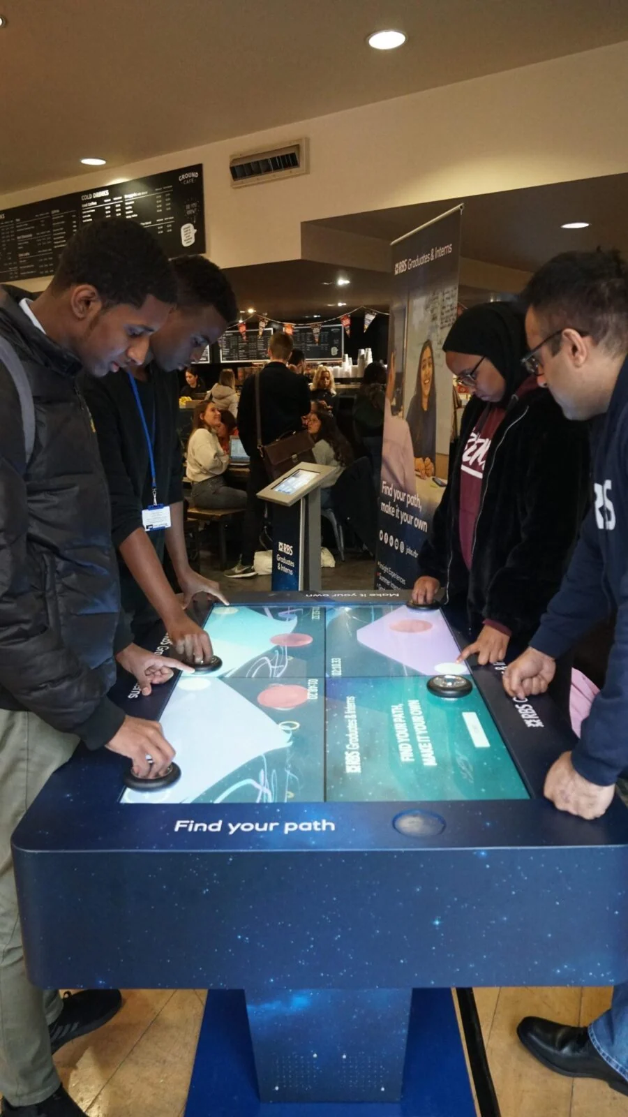 Visitors gathered around the Find Your Path interactive game table.