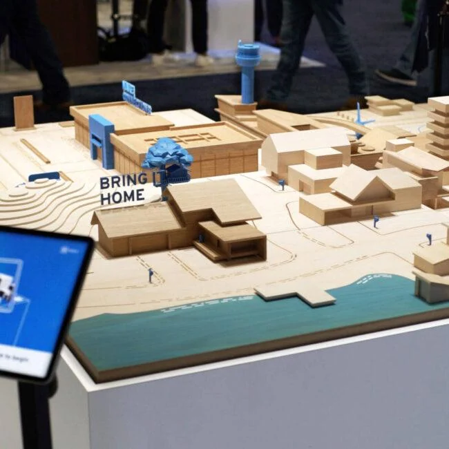 Wooden model city and tablet interface on the GM Energy augmented reality table.