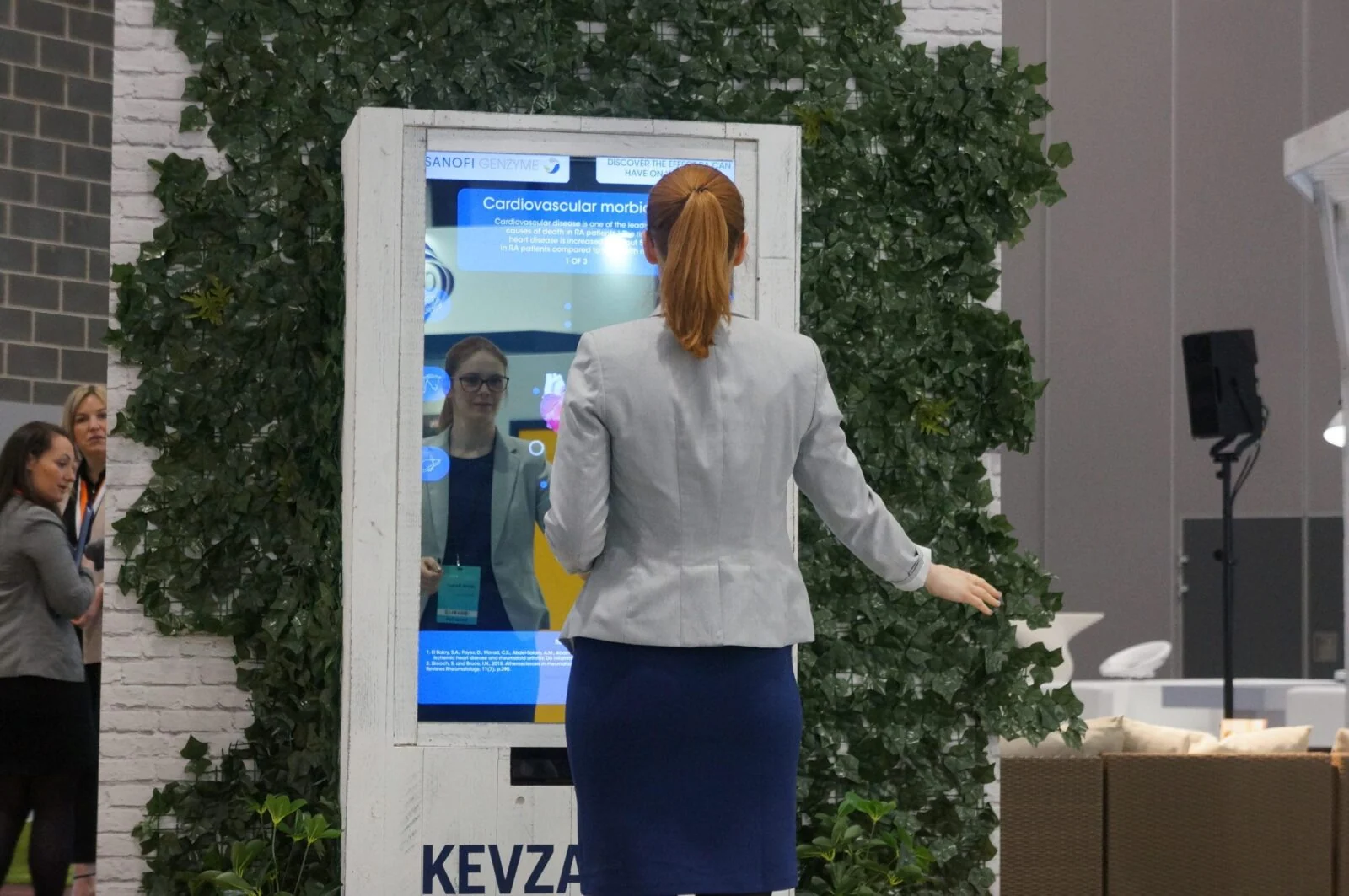 Visitor standing with arms out in front of the interactive X-ray mirror at an exhibition.