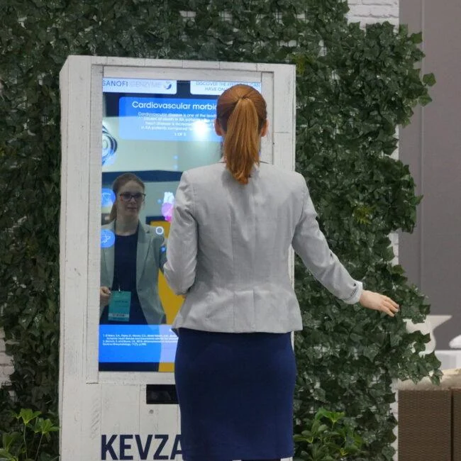 Visitor standing with arms out in front of the interactive X-ray mirror at an exhibition.