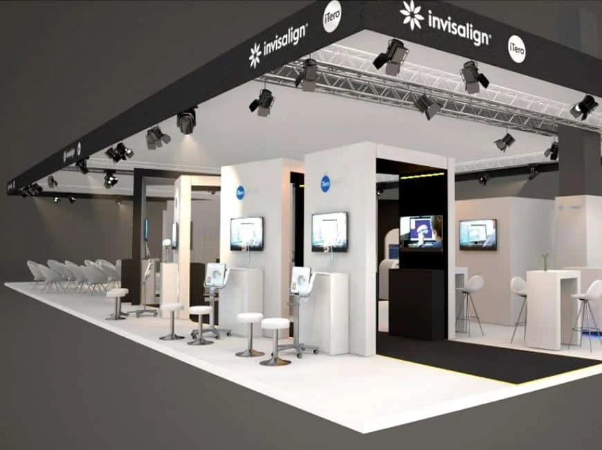 Invisalign exhibition stand with white display columns, screens and stools.