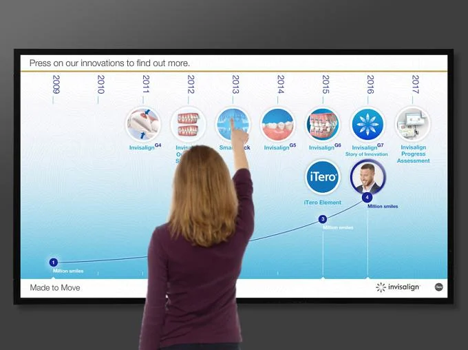 Visitor selecting a milestone on a large Invisalign interactive timeline.