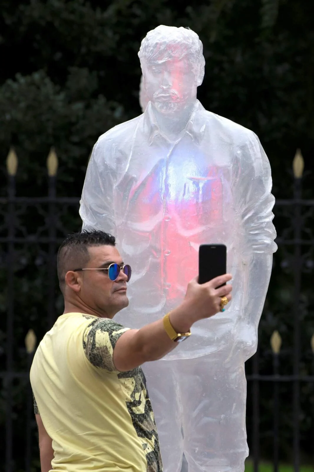 Visitor taking a selfie beside an illuminated translucent figure in the blood cancer awareness installation.