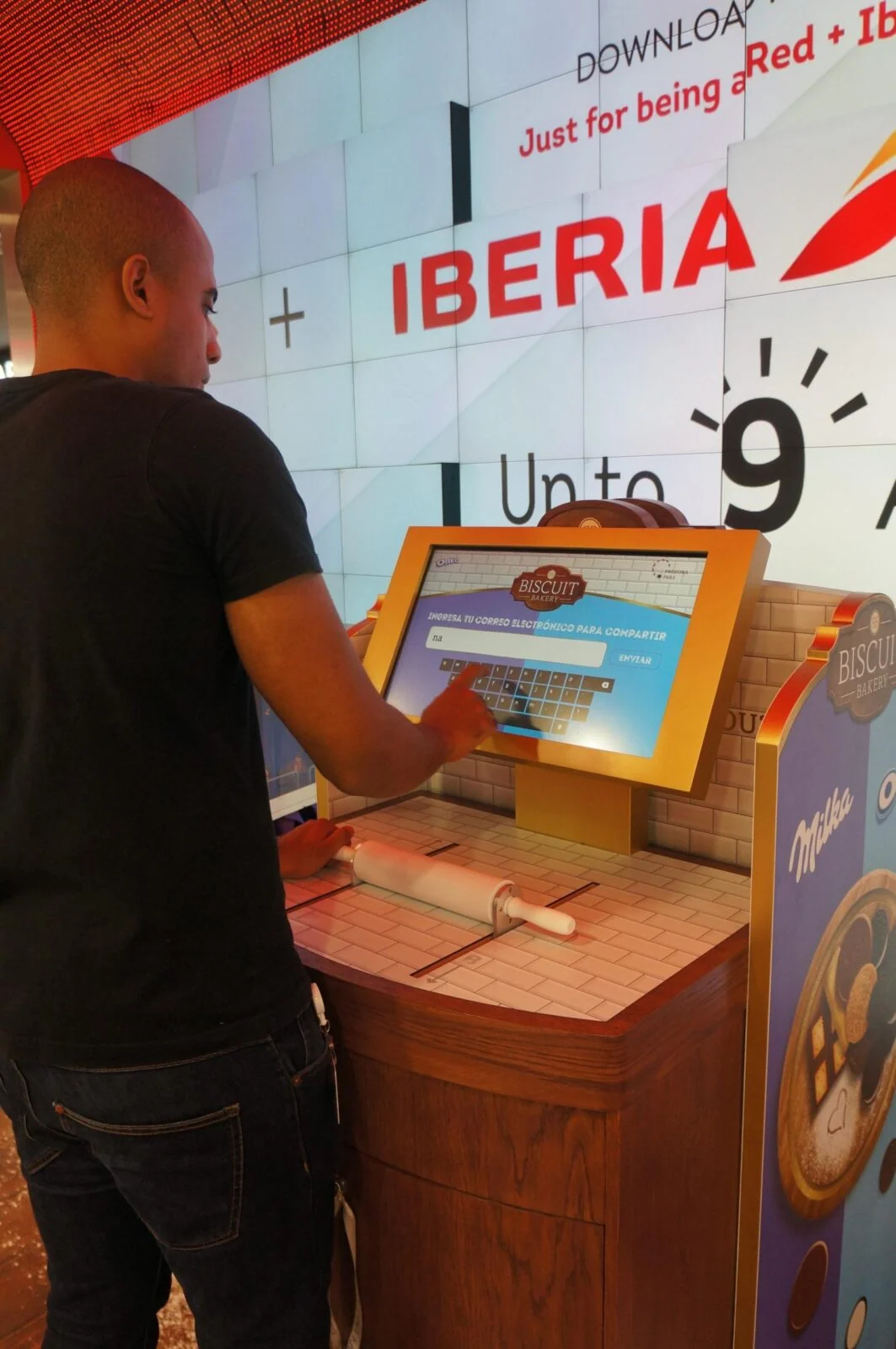 Visitor using a bakery-themed touchscreen kiosk at a Mondelez retail activation.