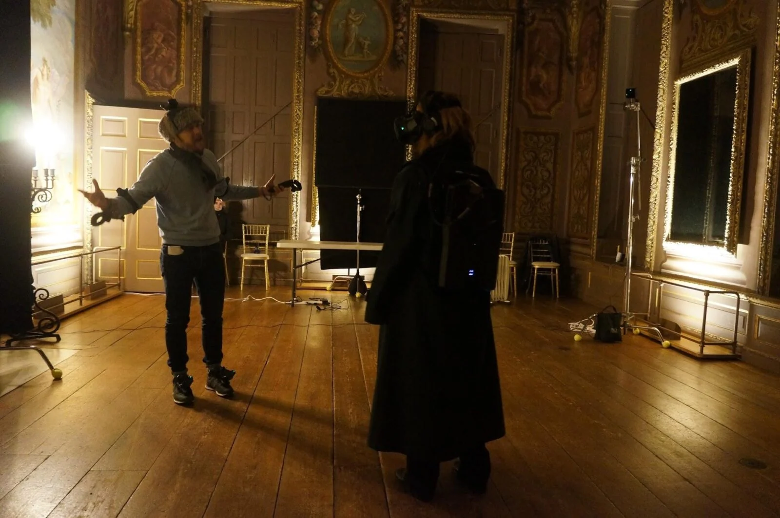 Two participants using VR headsets in a gilded room during the Pleasure Palace experience.