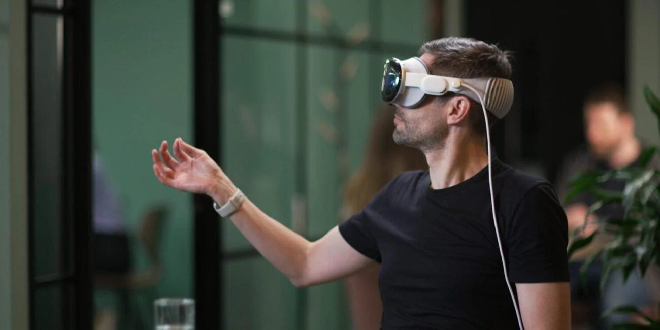 Person wearing a spatial-computing headset and raising a hand during the Discover London experience.