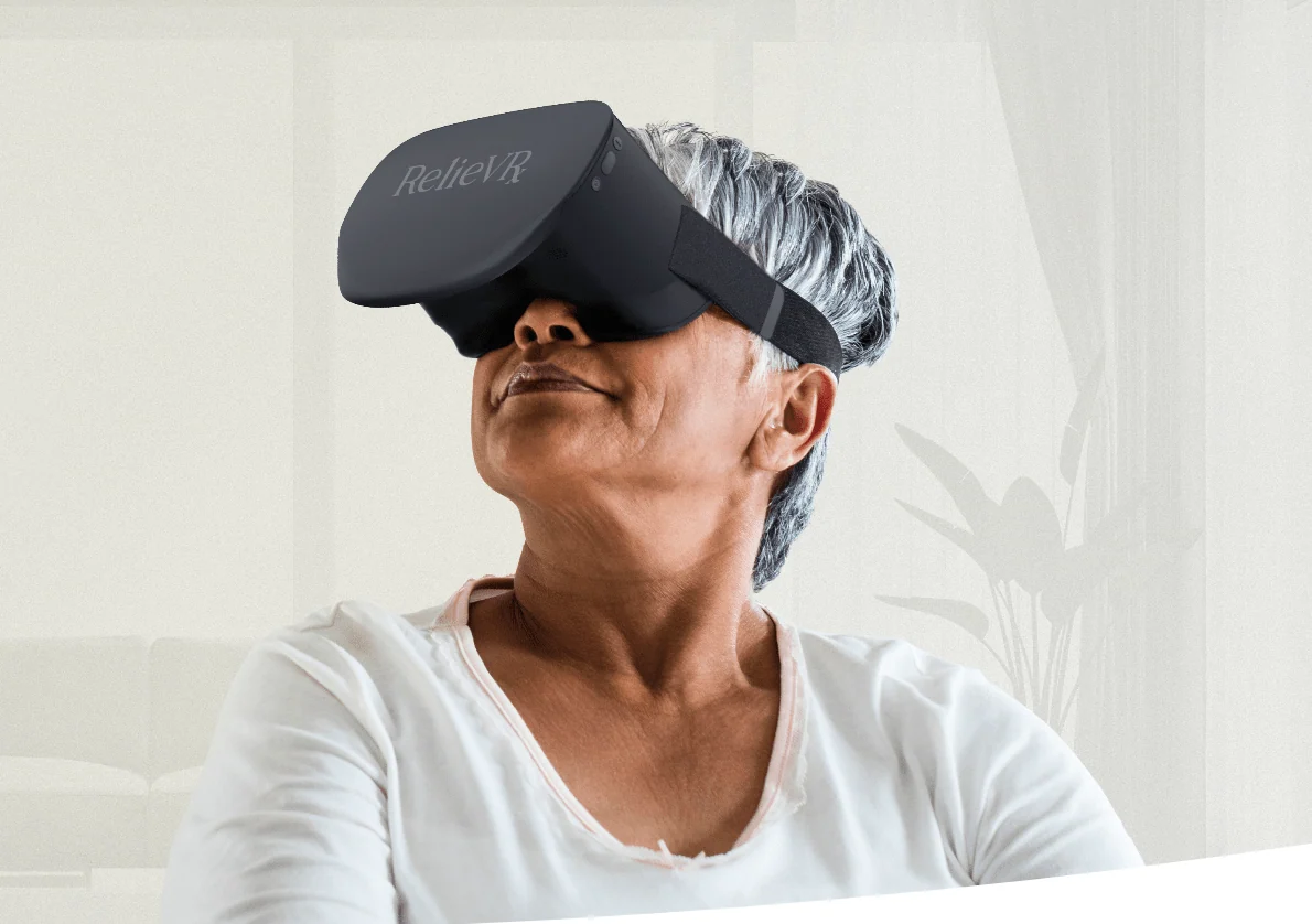 Participant wearing a RelieVRx virtual reality headset while seated in a bright room.