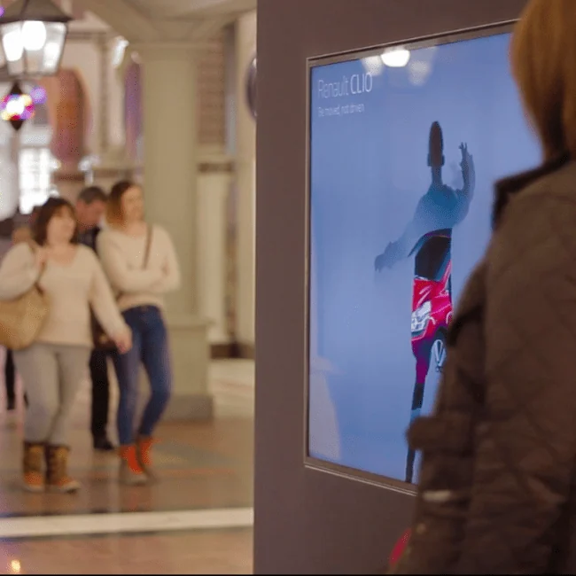 Visitor facing a Renault avatar display at a busy shopping centre activation.