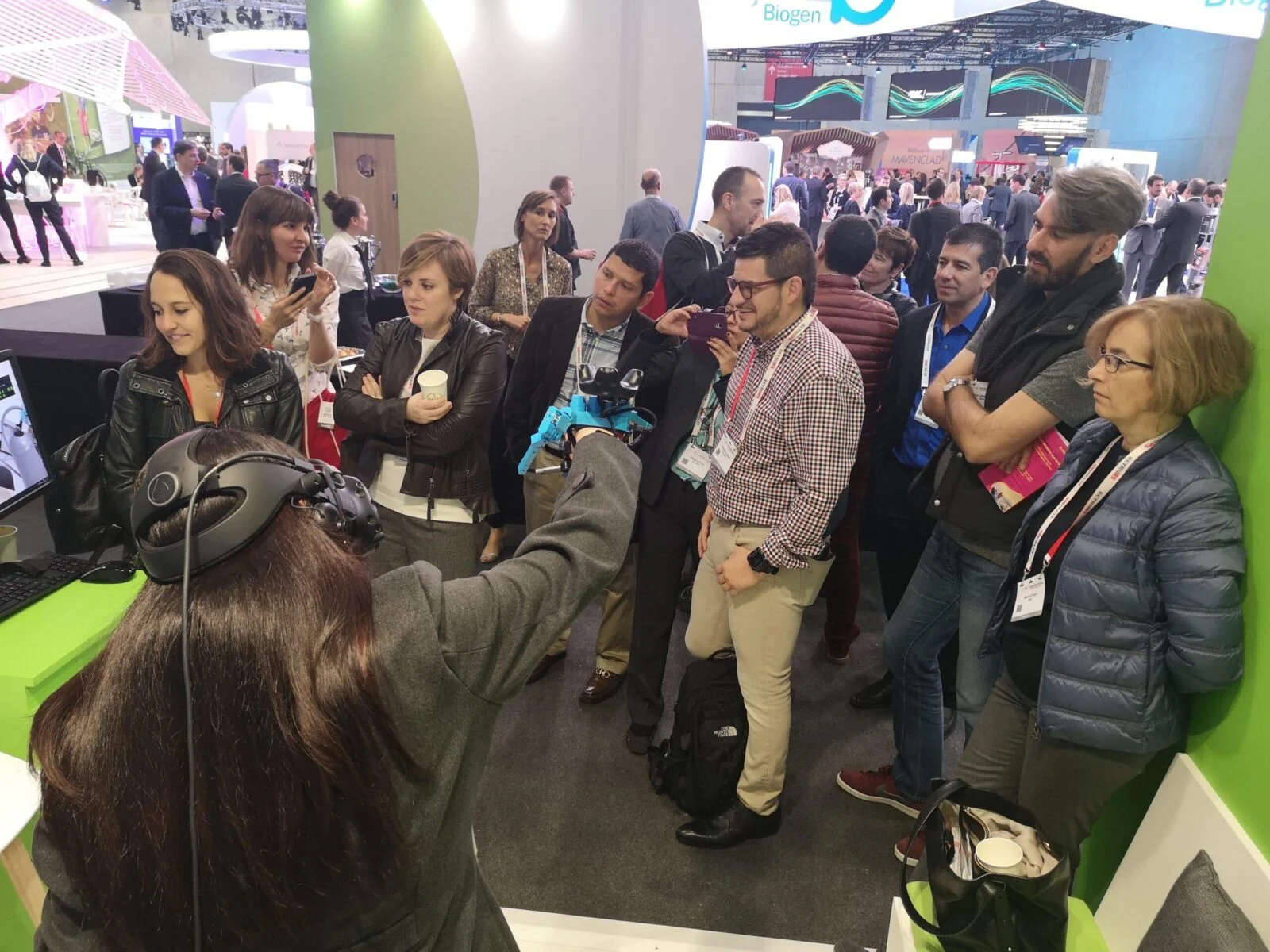 Exhibition visitors watching a participant try the Roche virtual reality experience.
