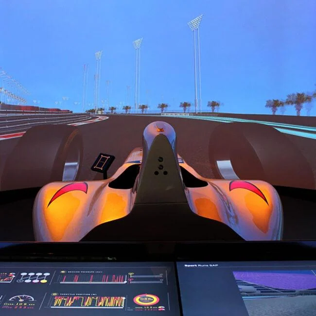 Orange race car on a panoramic display above an interactive dashboard.