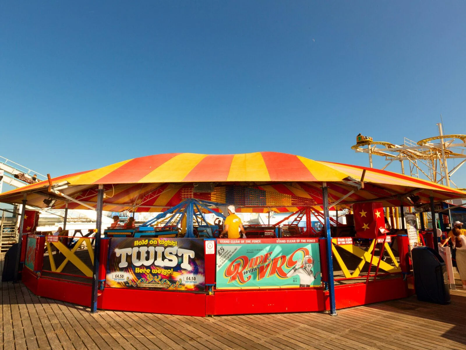 Twister fairground ride beneath a red and yellow canopy on Brighton Pier.