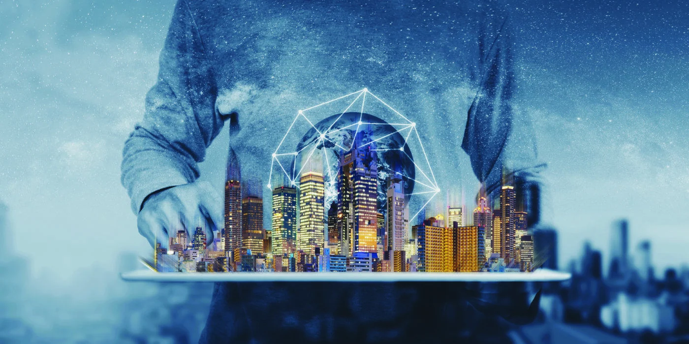 Digital city skyline floating above a tablet with a geometric network globe.