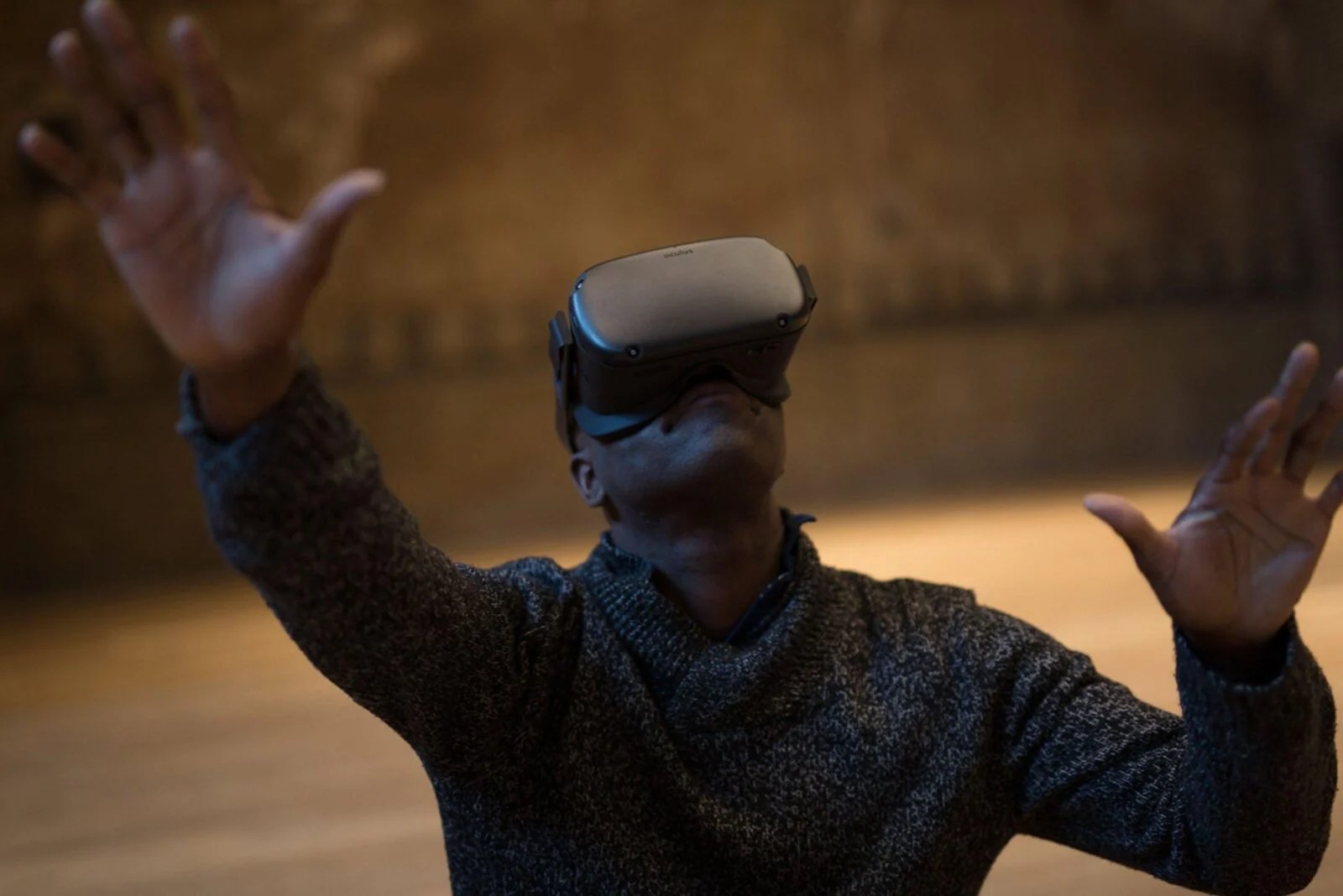Participant raising both hands while wearing a virtual reality headset.