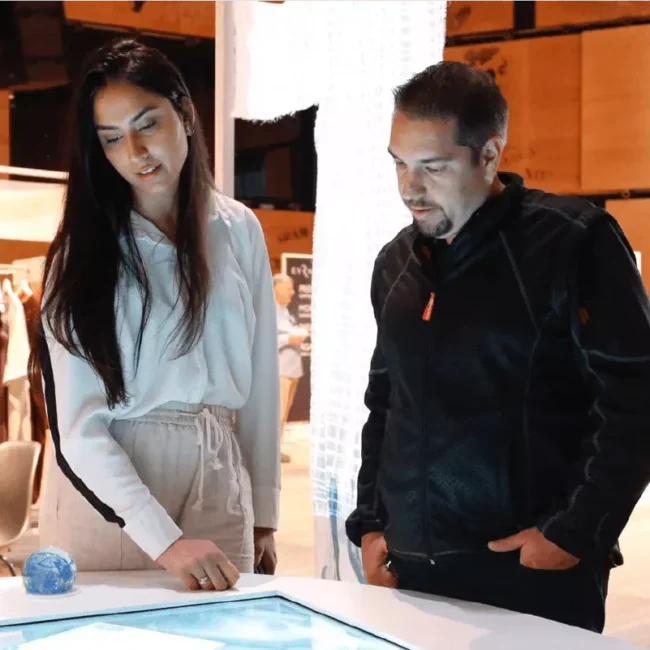Visitors looking down at a WaterAid interactive tabletop display.