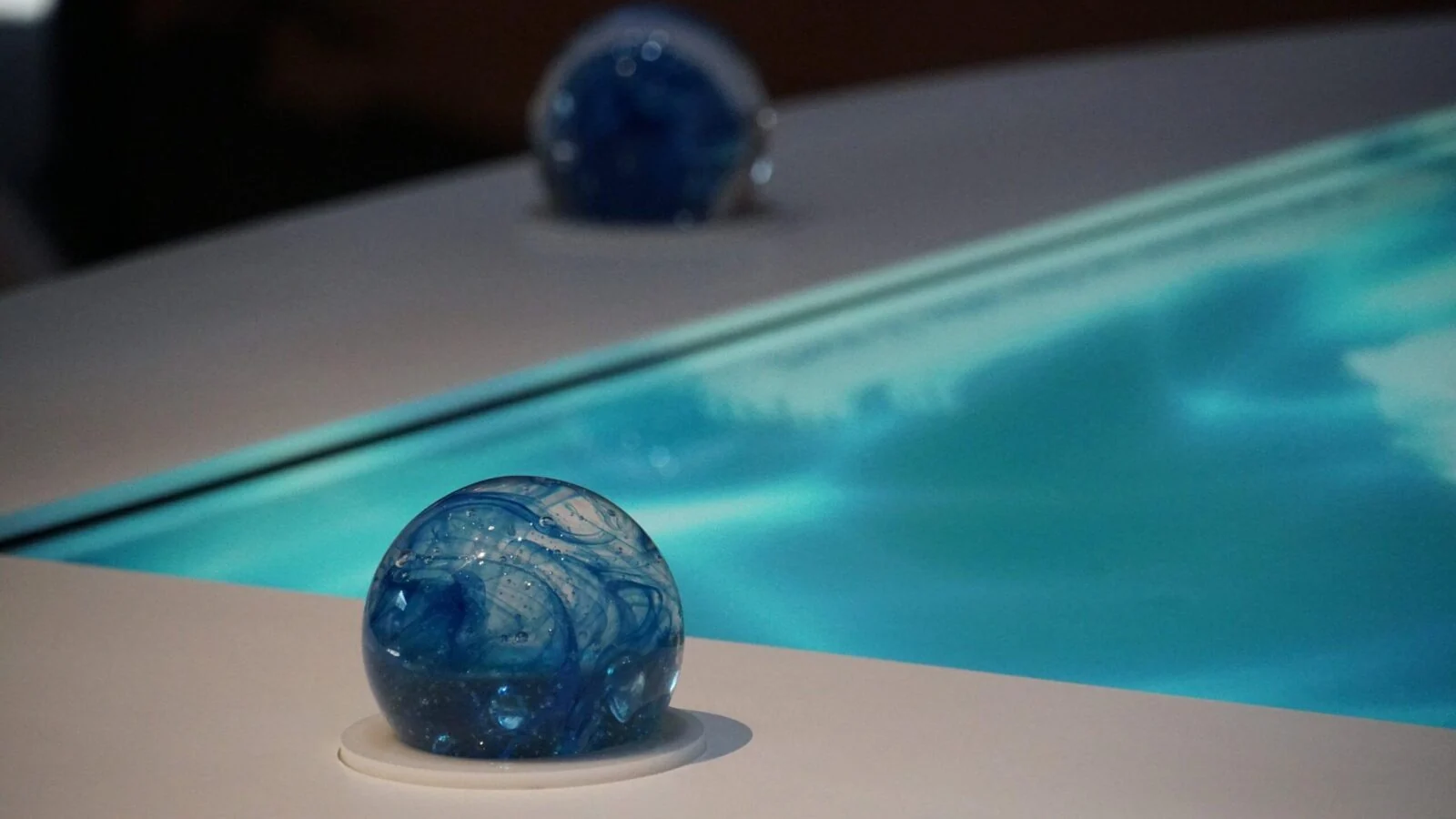 Blue globe-shaped control beside an illuminated tabletop display.